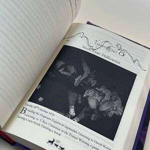 May include: An open book with a black and white illustration of a group of people. The text reads "Sixth Year: Halloween" and "Tuesday 26th October 1976". A red ribbon bookmark is visible.