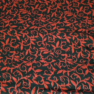 May include: Red and black fabric with a repeating pattern of stylized leaves and swirls.