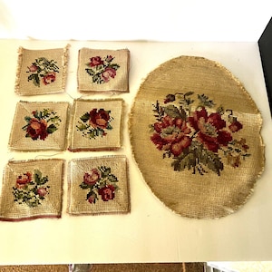 May include: Set of seven vintage needlepoint floral designs. The designs are all in shades of red, green, and beige. The designs are all in a square shape except for one which is oval.