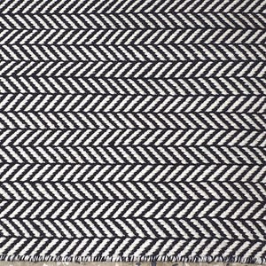 May include: A woven textile fabric featuring a repeating black and white herringbone pattern. The design consists of diagonal lines arranged in a V-shaped sequence across the entire surface, creating a consistent geometric texture throughout the material.