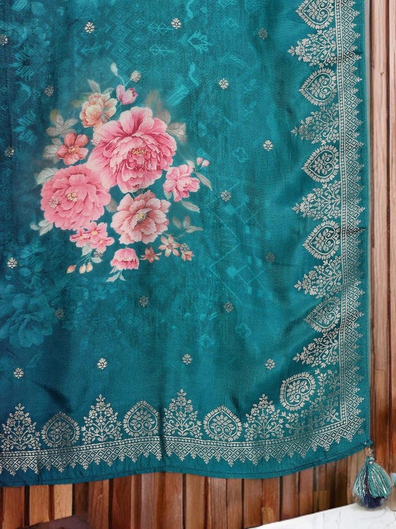 May include: Teal fabric with a floral design featuring large pink peonies and smaller peach-colored flowers. The fabric has a decorative border with a gold pattern and a tassel.