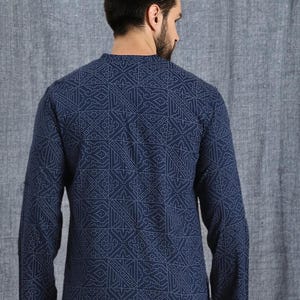 Pu&ograve; includere: Una camicia blu navy a maniche lunghe con un motivo geometrico bianco. La camicia ha un colletto alla coreana ed &egrave; realizzata in un materiale morbido e confortevole. Un'aggiunta elegante a qualsiasi guardaroba.