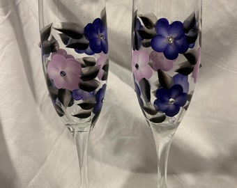 Champagne glasses with a mix of hand painted dark purple and lilac colored flowers.