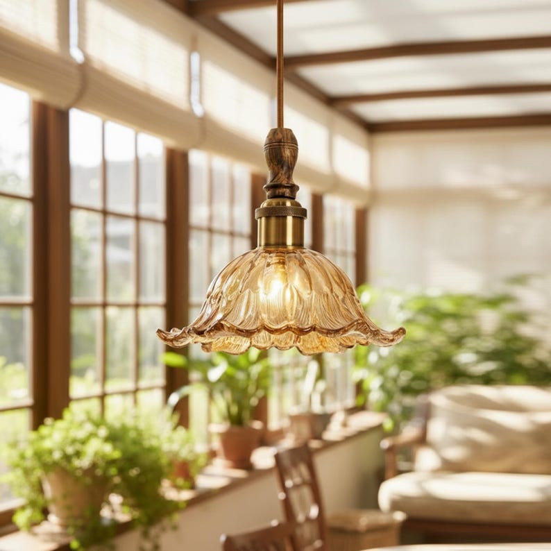 May include: A pendant light fixture featuring a scalloped, amber-tinted glass shade with a fluted petal design. The lamp includes a brass-toned metal socket housing and a dark, wood-grain textured cylindrical top piece suspended by a cord.