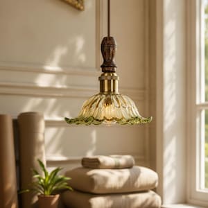 May include: A pendant light fixture featuring a fluted, translucent green glass shade with a scalloped edge. The shade is attached to a brass-toned metal fitting and a dark brown, turned wooden handle, suspended by a brown fabric-covered cord.