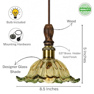 May include: A pendant light featuring a scalloped, amber-tinted glass shade, a brass E27 holder, and a dark wood accent piece. The fixture includes mounting hardware and a bulb. Dimensions are 5 inches in height and 8.5 inches in width.