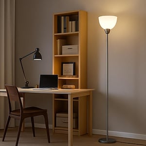 Puede incluir: Un espacio de oficina en casa con un escritorio, una silla y una estantería de madera. Una lámpara de escritorio negra y un portátil están sobre el escritorio. Una lámpara de pie alta con una pantalla blanca proporciona iluminación adicional. La habitación tiene una paleta de colores neutros.