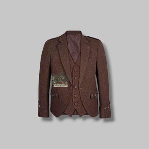 Puede incluir: Un conjunto de chaqueta, chaleco y pantalón de tweed marrón. La chaqueta tiene solapas con muescas, puños abotonados y un pequeño parche con el texto "PIPERS & MASONS". El chaleco tiene cierre de cinco botones. El conjunto es de tejido texturizado.