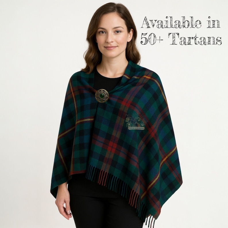 May include: A green, blue, and red plaid shawl with a decorative brooch. The shawl has a fringed edge and a crest emblem. Text in the image reads "Available in 50+ Tartans."