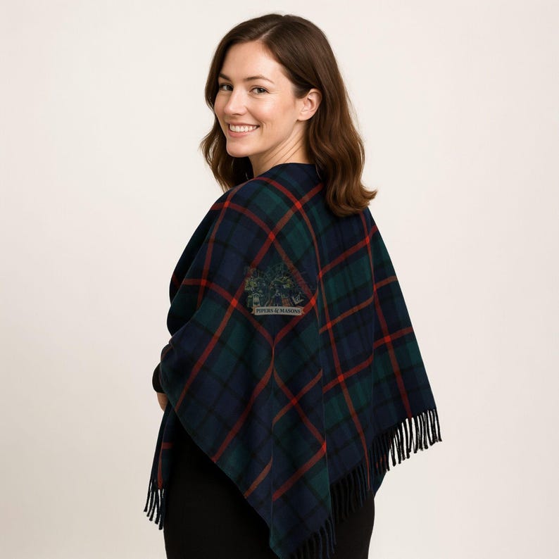 May include: A navy, green, and red plaid shawl with fringe. The shawl has a square patch with the text "PIPERS & MASONS" and a tree design. The shawl is draped over the shoulders.