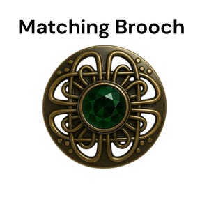 May include: A round, antique-style brooch with a central emerald-green gemstone. The brooch features an intricate, Celtic-inspired knotwork design in a bronze-colored metal. The text "Matching Brooch" is displayed above the brooch.