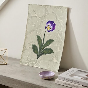 May include: A set of three ceramic mugs with a speckled, matte finish. The mugs are in shades of cream, light gray, and dark gray. Each mug has a simple, minimalist design, perfect for coffee or tea.