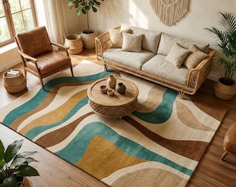 May include: A living room scene featuring a large area rug with a wavy pattern in shades of brown, beige, teal, and gold. The room includes a rattan sofa, leather armchair, and a round wooden coffee table. Decorative plants and woven baskets add to the decor.