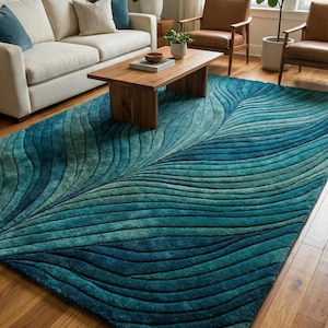 May include: A large, teal and blue area rug with a leaf-like design dominates the room. The rug's pattern features layered, curved lines, creating a textured effect. The rug is placed on a hardwood floor, complementing the room's neutral color scheme.