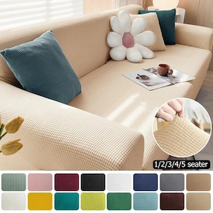 May include: Beige textured sofa cover with matching throw pillows in blue and white. A daisy-shaped pillow and a coffee cup are on the sofa. The image also shows a variety of color options for the sofa cover.