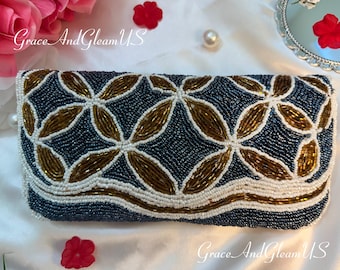 May include: A rectangular beaded clutch in navy blue, white, and gold. The clutch features a floral pattern with gold and white beads on a navy blue background. The text "Grace And Gleam US" is visible.