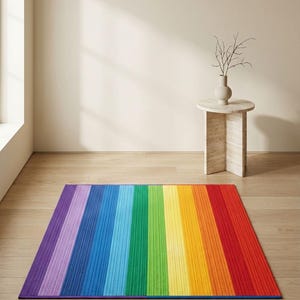 Op de afbeelding: Een rechthoekig tapijt met een regenboogstreepontwerp. Het tapijt heeft verticale strepen in de kleuren van de regenboog, van paars tot rood. Het tapijt ligt op een houten vloer.