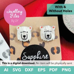 May include: A pair of white polar bear head earrings with black facial features and orange inner ears, displayed on a tan card with a leopard print pattern. The card features the text Jewellery Files By SF, Sapphire, and With & Without Holes.