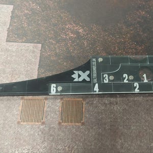 Può includere: Sagoma di gioco in acrilico trasparente con segni neri e la scritta "SALTIRGAMES.CO.UK". La sagoma presenta sezioni numerate da 1 a 9, progettata per giochi da tavolo. La sagoma è lunga circa 23 cm.