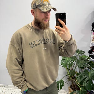 May include: A handmade wooden sign with the text "Welcome" in a handwritten style. The sign is painted white with a distressed finish, and a small green leaf is attached to the top. The sign measures approximately 12 inches wide.