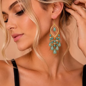 May include: A gold-toned chandelier earring featuring a central marquise-shaped frame, accented with turquoise-colored beads and multiple dangling teardrop-shaped stones in a soft seafoam green hue, suspended from a delicate gold-toned chain.