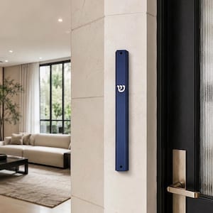 May include: A long, vertical, dark blue mezuzah case with a matte finish, featuring a white Hebrew letter Shin centered on the front. The rectangular case has beveled edges and two small circular mounting holes at the top and bottom ends.