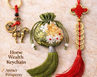 May include: A gold-toned horse keychain with a Chinese coin, a green fabric pouch with white and gold floral embroidery and a green tassel, and a red decorative knot with five gold-toned coins and a long red tassel, featuring text.