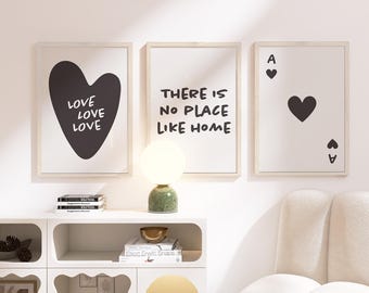 Puede incluir: Tres impresiones artísticas enmarcadas con paspartús blancos. Una presenta un corazón negro con las palabras "LOVE LOVE LOVE". Otra dice "THERE IS NO PLACE LIKE HOME". La tercera muestra un as de corazones.
