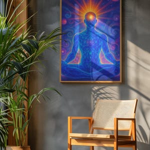 May include: A framed art print depicting a meditating figure in a cosmic setting. The figure is rendered in blue with a glowing orange light emanating from the head. The background features swirling galaxies and planets. A wooden chair and potted plant are in the foreground.
