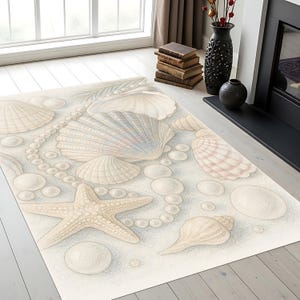 Puede incluir: Una alfombra rectangular con diseño de playa. Muestra conchas marinas, una estrella de mar y hilos de perlas en tonos beige, crema y azul claro. El diseño evoca una escena de playa arenosa, ideal para interiores costeros.