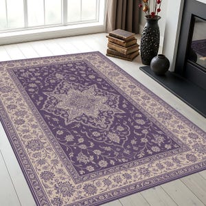 May include: A rectangular purple area rug with a central floral medallion and a beige border featuring floral patterns. The rug is placed on a light-colored wooden floor, creating a contrast in the room.