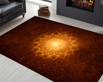 May include: A rectangular area rug with a warm color palette. The rug features a central, glowing mandala design in shades of gold and orange, set against a dark brown background with a speckled pattern. The rug is placed on a light-colored wooden floor.