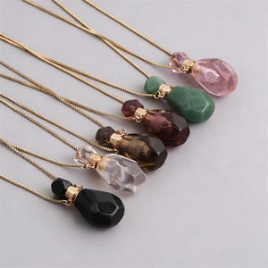 Peut inclure: Plusieurs colliers avec pendentifs en pierres précieuses de différentes couleurs : rose, vert, violet, marron, transparent et noir. Chaque pendentif est attaché à une fine chaîne dorée. Les pendentifs sont taillés en forme de goutte.