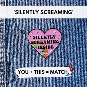 Peut inclure: Épinglette en émail rose en forme de cœur avec les mots "SILENTLY SCREAMING INSIDE" en noir. L'épinglette présente un arc-en-ciel et de petits cœurs. L'épinglette est sur un fond en denim bleu. Le texte au-dessus de l'épinglette se lit "SILENTLY SCREAMING".
