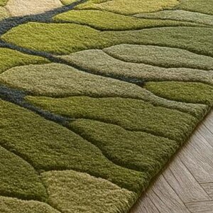 May include: A green area rug with a leaf-like pattern. The rug features varying shades of green, from light to dark, with a dark gray border. The rug is placed on a wooden floor.