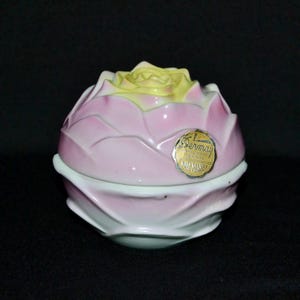 May include: A vintage Dermay bath powder container. The container is shaped like a pink and yellow rose. The lid is yellow, and the petals are pink. A gold label with text is on the front.