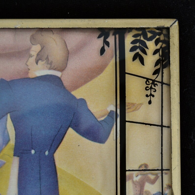 K&ouml;nnte beinhalten: Eine gerahmte Vintage-Illustration eines Mannes im blauen Anzug und einer Frau im wei&szlig;en Kleid, die in einem Garten tanzen. Das Bild ist in einem goldenen Rahmen mit schwarzem Passepartout.