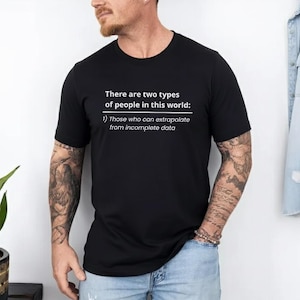 May include: Black t-shirt with white text: "There are two types of people in this world: 1) Those who can extrapolate from incomplete data." The shirt is short-sleeved and worn by a person.