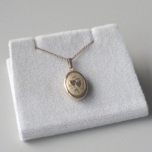 Small oval locket with heart design on front complete with chain and box