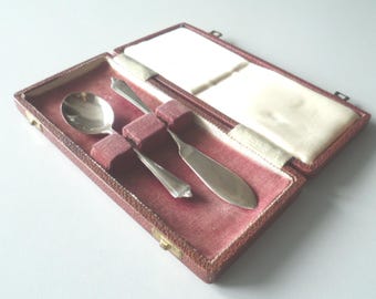 Juego antiguo de cuchillo para mantequilla, cuchara para mermelada y conservas de plata con sello distintivo, en su estuche original.