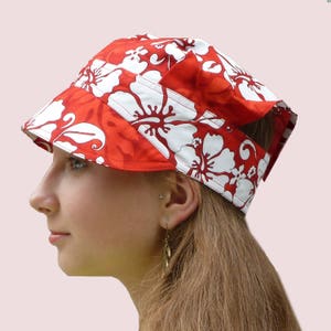 May include: A red and white floral print sun hat with a wide brim and a unique design. The hat is made of cotton fabric and has a comfortable fit.