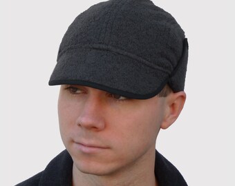 Sombrero Explorer para hombre Trooper con orejeras y visera en tejido de alpaca y lana gris oscuro con detalles técnicos impermeables y forro polar.