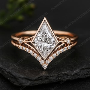 May include: Rose gold engagement ring set with a kite-shaped diamond center stone and a diamond-studded band. The set includes a matching contoured band with small diamonds. The ring is displayed on a black surface.