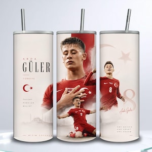 May include: A cylindrical tumbler with a straw featuring a graphic design of soccer player Arda Güler in a red jersey. The design includes the Turkish flag, the number 8, the text Arda Güler, Türkiye, Talent, Passion, Belief, and Bizim Çocuklar.