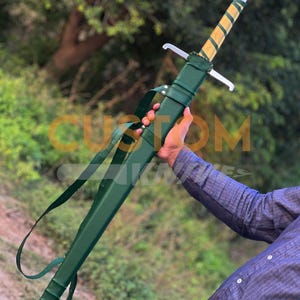 May include: A long sword with a silver blade and a wooden handle wrapped in gold and green. The sword is in a green sheath with a shoulder strap. The sword is held by a person.