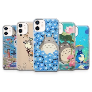 May include: A collection of five phone cases featuring colorful illustrations. The cases showcase various designs, including a gray Totoro character, blue floral patterns, and scenes with other animated characters. The cases are designed to fit a smartphone.