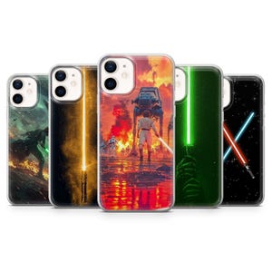 May include: A collection of phone cases featuring Star Wars-themed designs. The cases display various scenes with lightsabers, characters, and iconic imagery from the movies. The cases have a clear border and a glossy finish.