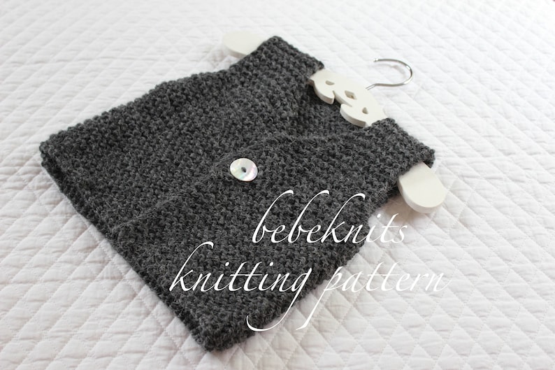 May include: A grey knitted vest with a white button and the text "bebeknits knitting pattern".