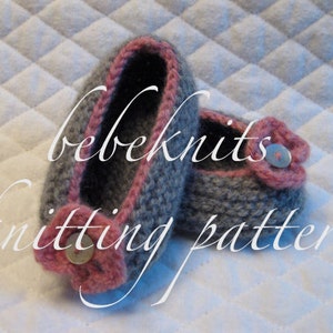 May include: A pair of gray and pink knitted baby booties with a button detail. The booties are on a white quilted fabric background. The text "bebeknits knitting pattern" is visible in the image.
