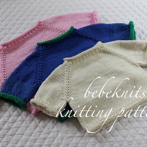 Puede incluir: Tres jerséis de punto para bebé en rosa, azul y blanco con ribetes verdes alrededor del cuello y las mangas. Los jerséis están apilados uno encima del otro y el texto "bebeknits knitting pattern" es visible en la parte inferior de la imagen.